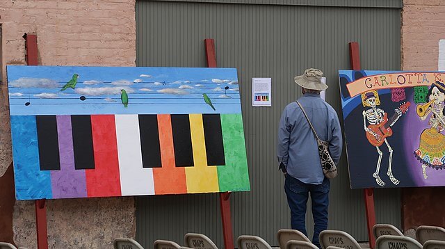 A man at the Jazz Festival looking at a painting / Wikimedia Commons / Jose Lozano

Link: https://upload.wikimedia.org/wikipedia/commons/thumb/2/28/Latin_Jazz_Festival.jpg/640px-Latin_Jazz_Festival.jpg